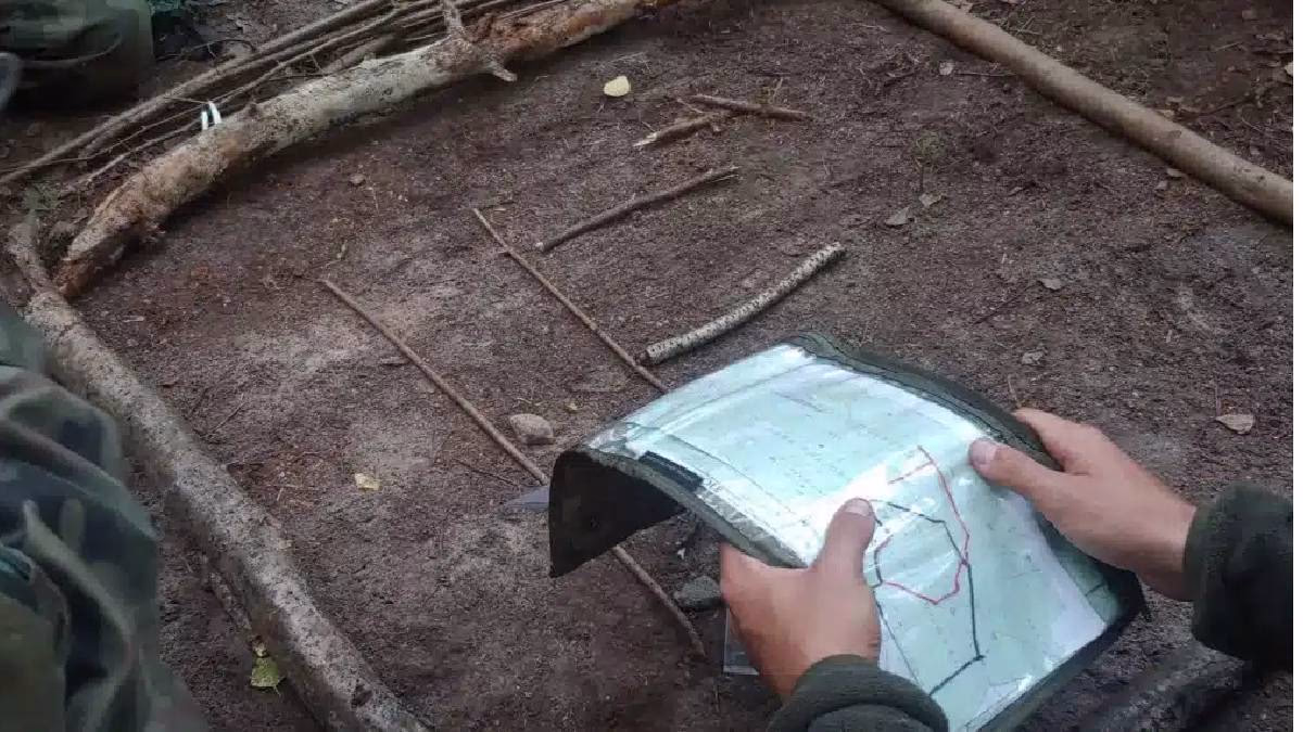 Uczestnik wycieczki szkolnej EDB analizuje mapę terenu przy makiecie taktycznej w trakcie warsztatów.