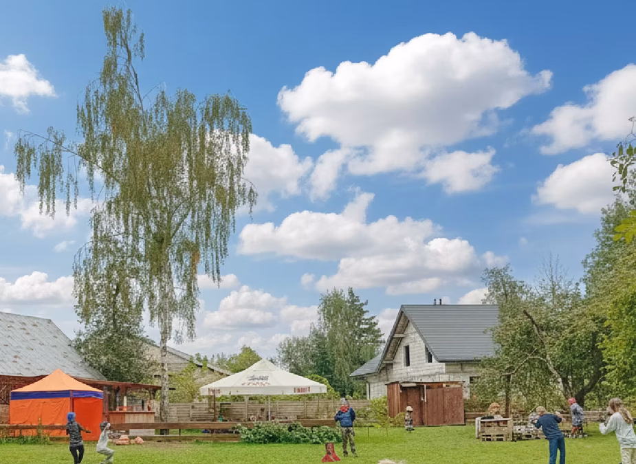 Dzieci bawiące się na polanie w parku rozrywki Las Odkrywców podczas wycieczki szkolnej.